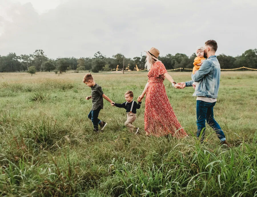 Parents walking through a field with their children